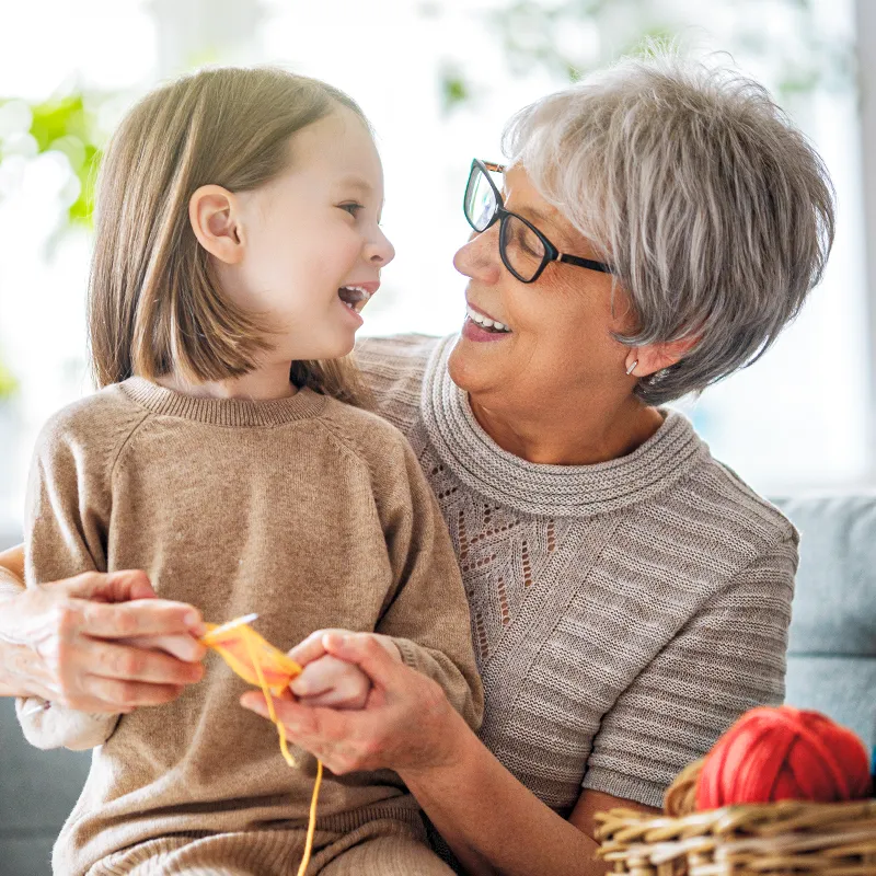 Grandmother and granddaughter smiling at each other
